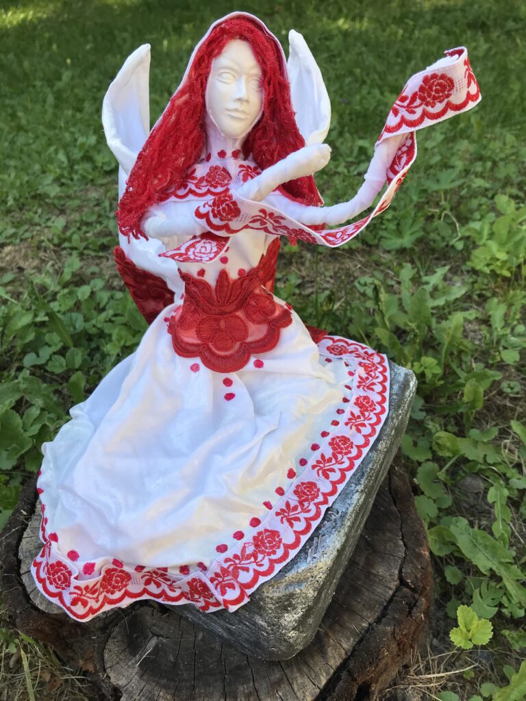 Socha sediaci anjel s červenými vlasmi