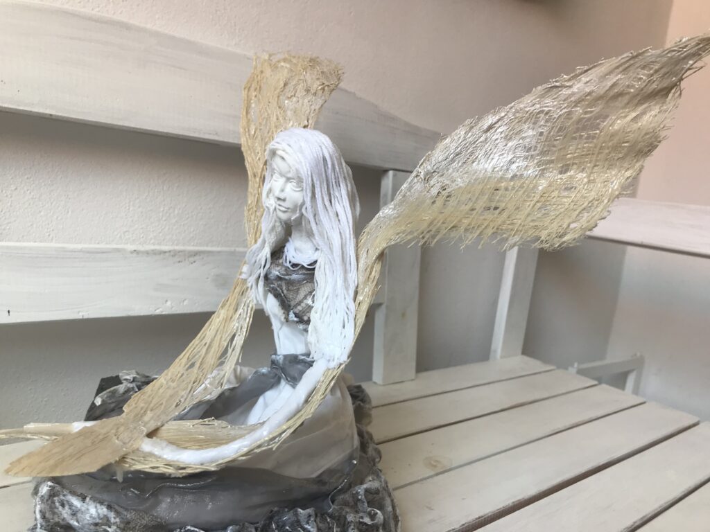 Socha sediaci anjel s krémovými krídlami